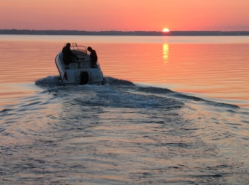 A boat motoring off into the sunset.