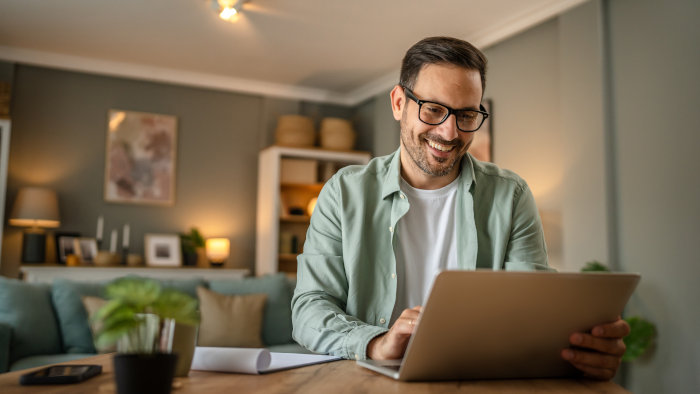 A guy is using a budget calculator worksheet and spreadsheet that guides you and provides you with advice on your budget.