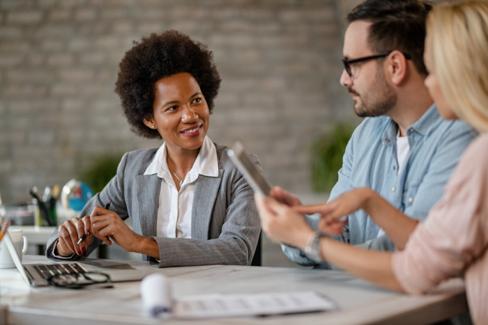 A credit counsellor with a couple providing potential debt help, interest relief, and debt solutions through credit counselling.