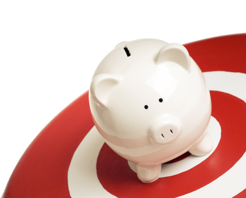 A piggy bank in the middle of a red and white target symbolizing someone trying to achieve their financial goals.