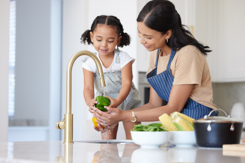 A mother teaching her daughter about budgeting by selecting and preparing the fresh produce they have chosen.